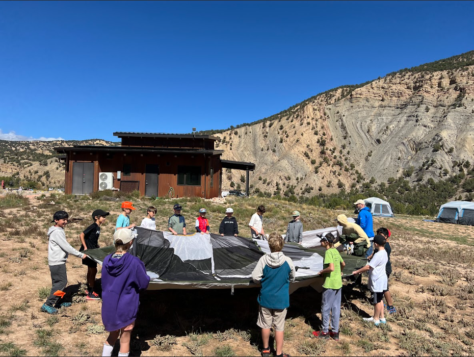 5th graders working together to set up a tent to sleep in for the 2-night hut trip. 